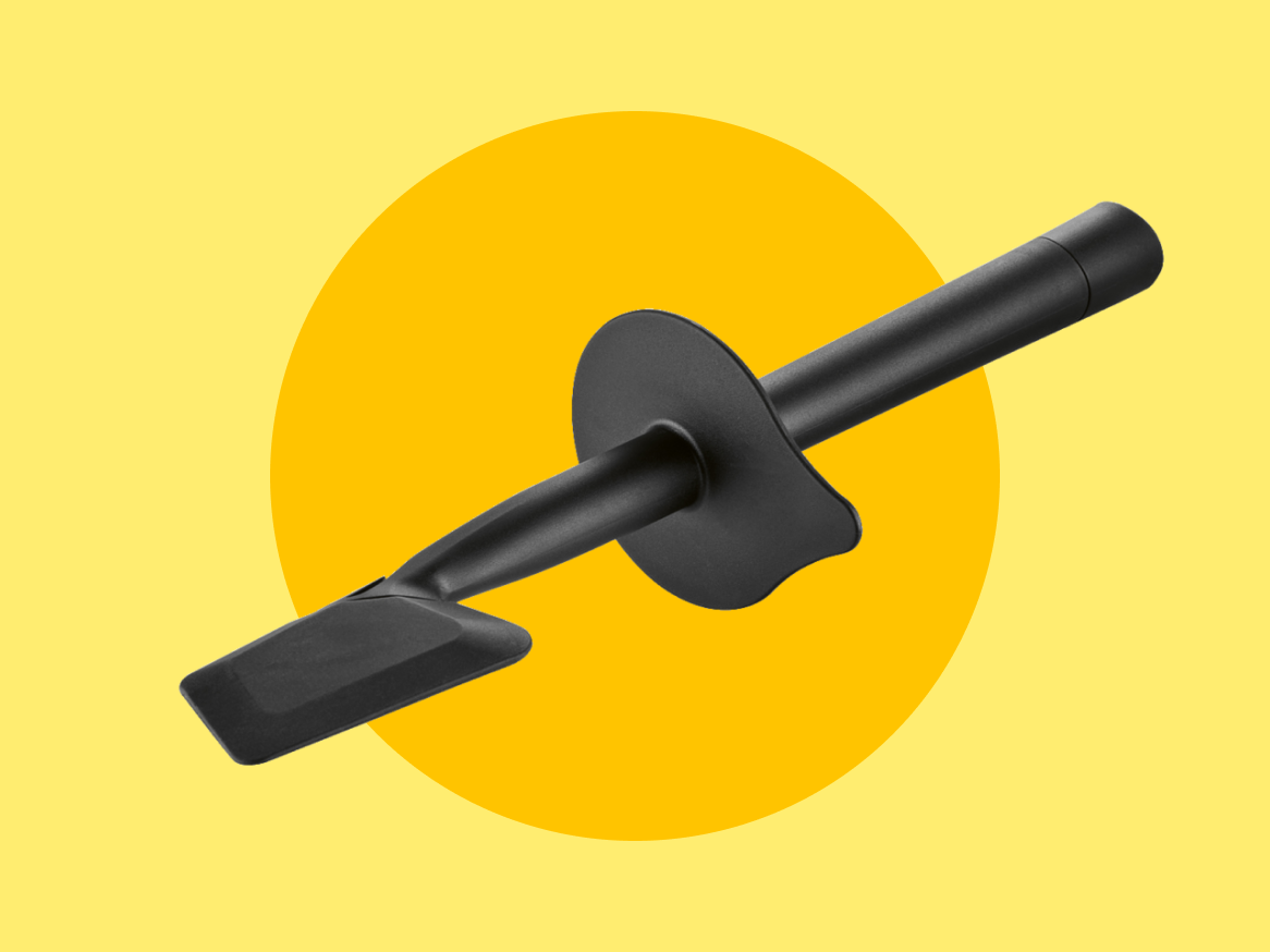 Espátula de silicone preta sobre fundo amarelo.