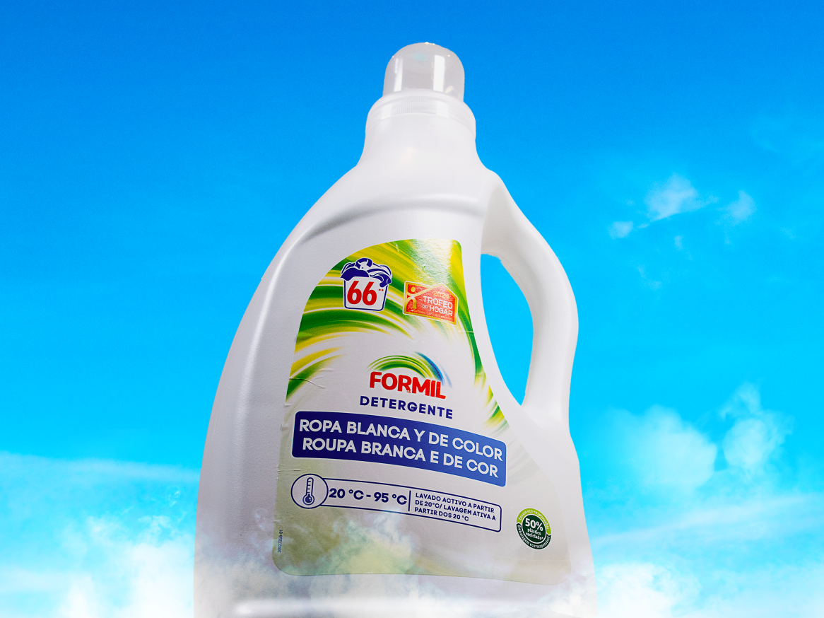 Frasco de detergente Formil para roupas brancas e coloridas, contra um fundo de céu azul.