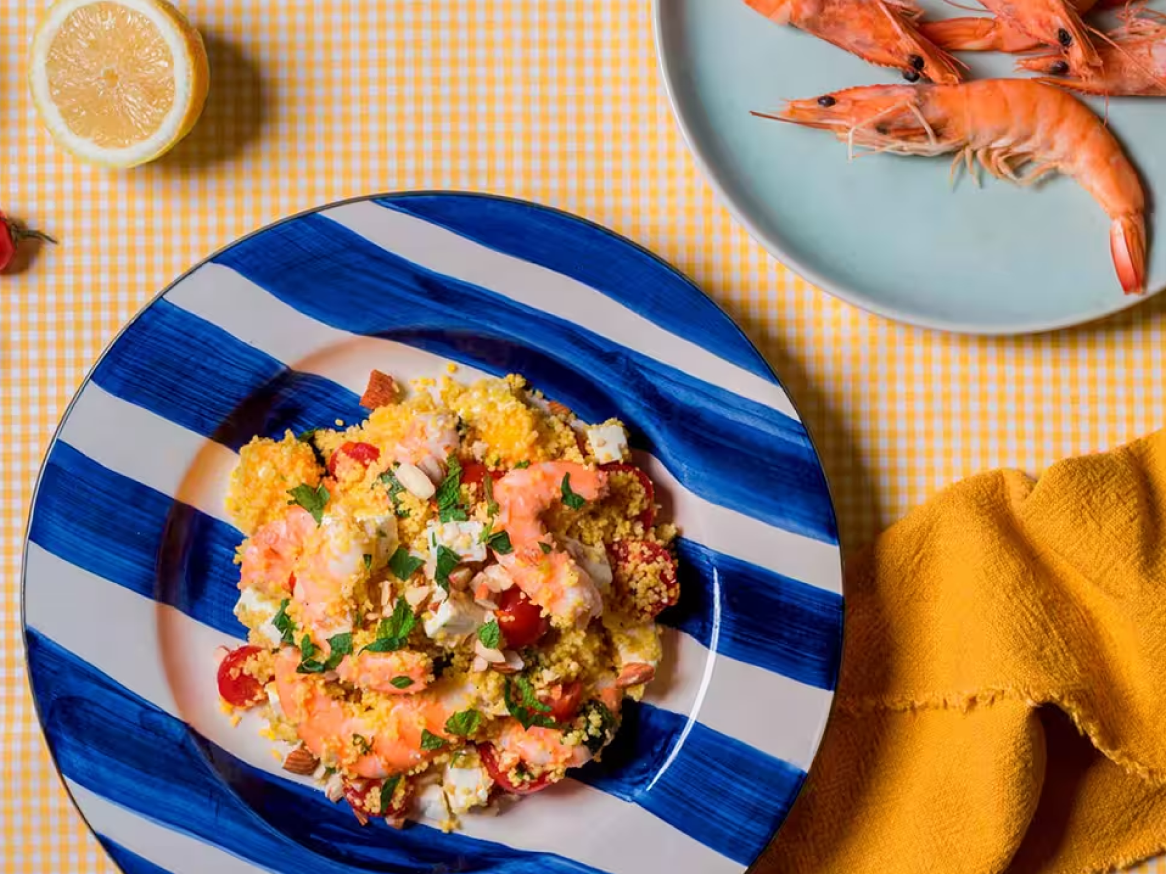Salada de cuscuz com camarão, tomate cereja, queijo feta e amêndoas, com limão e camarões cozidos.