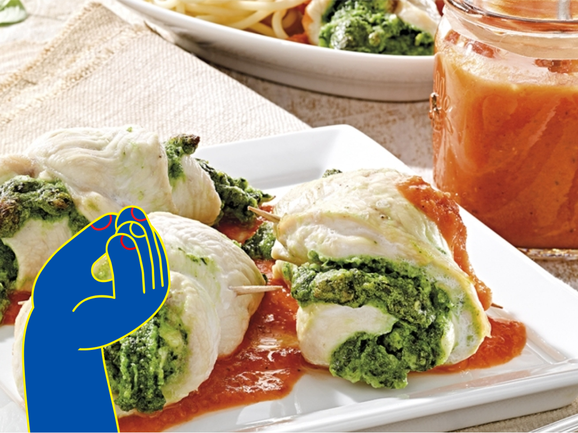 Rolinhos de frango recheados com pesto, servidos com molho de tomate.