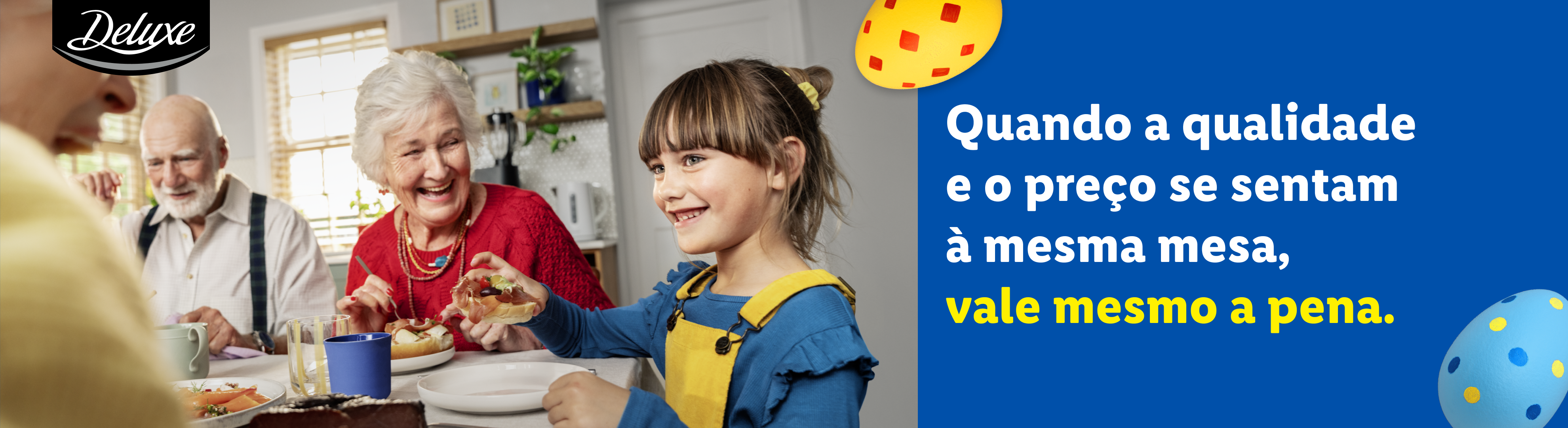 Uma família feliz a desfrutar de uma refeição à mesa, com a frase 'Quando a qualidade e o preço se sentam à mesma mesa, vale mesmo a pena.'