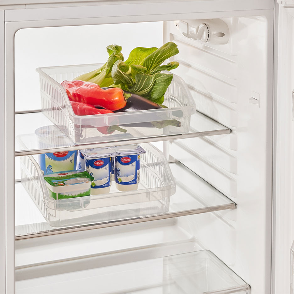 Frigorífico com organizadores transparentes cheios de vegetais, iogurtes e queijo.