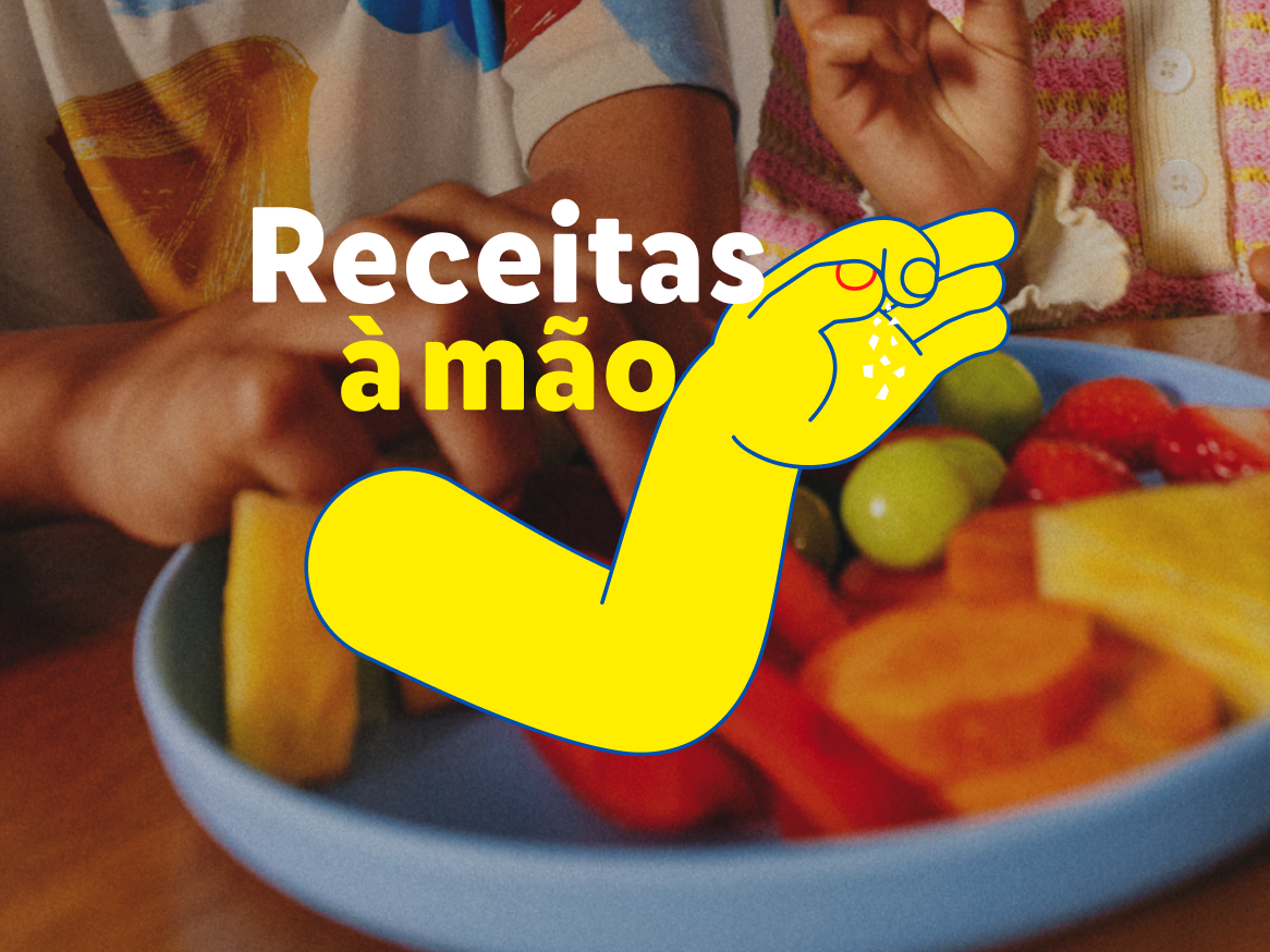 Mãos a preparar uma salada de frutas colorida, com o texto 'Receitas à mão' e uma ilustração de uma mão a temperar.
