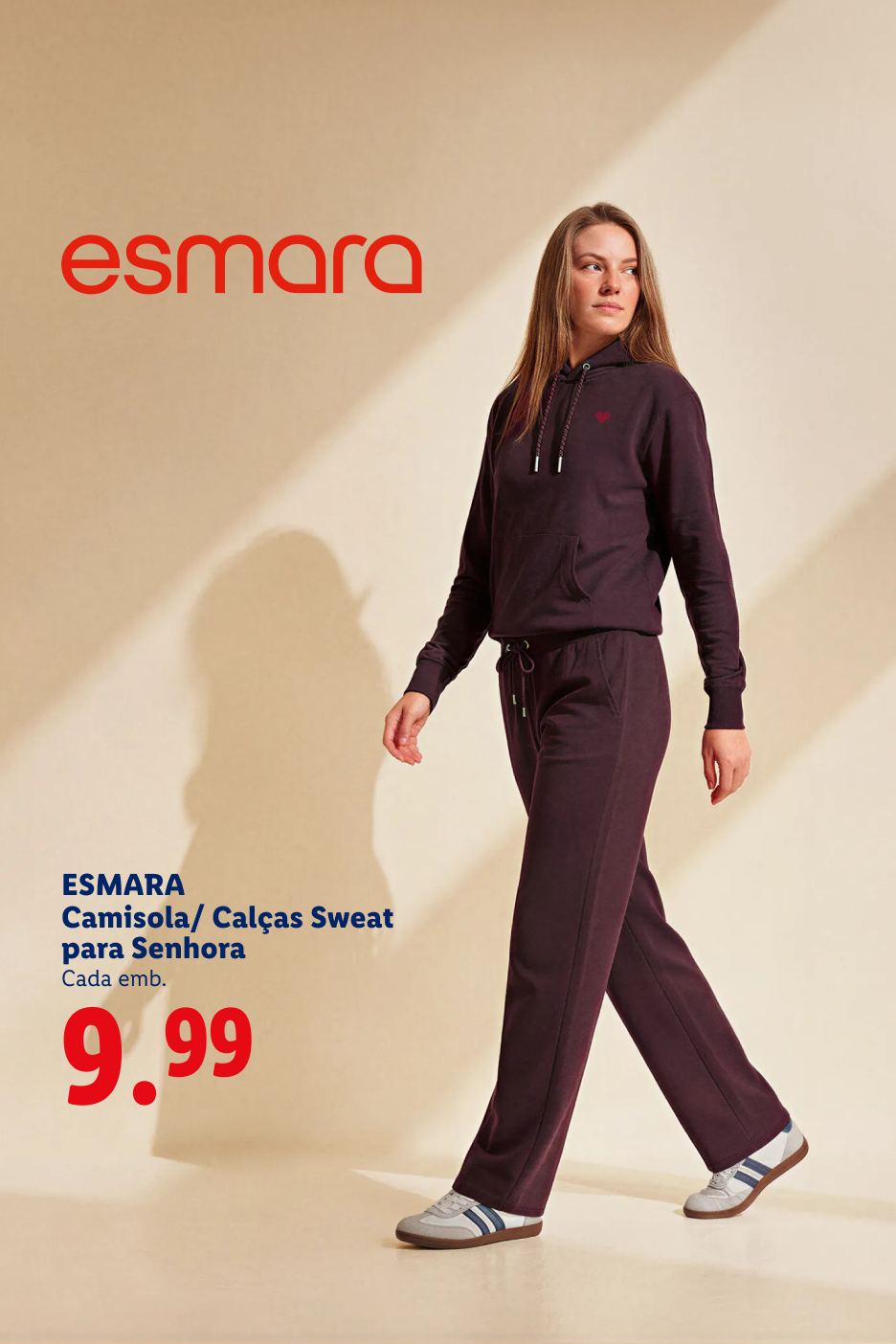 Mulher a caminhar com camisola e calças de fato de treino roxas, por 9,99€.