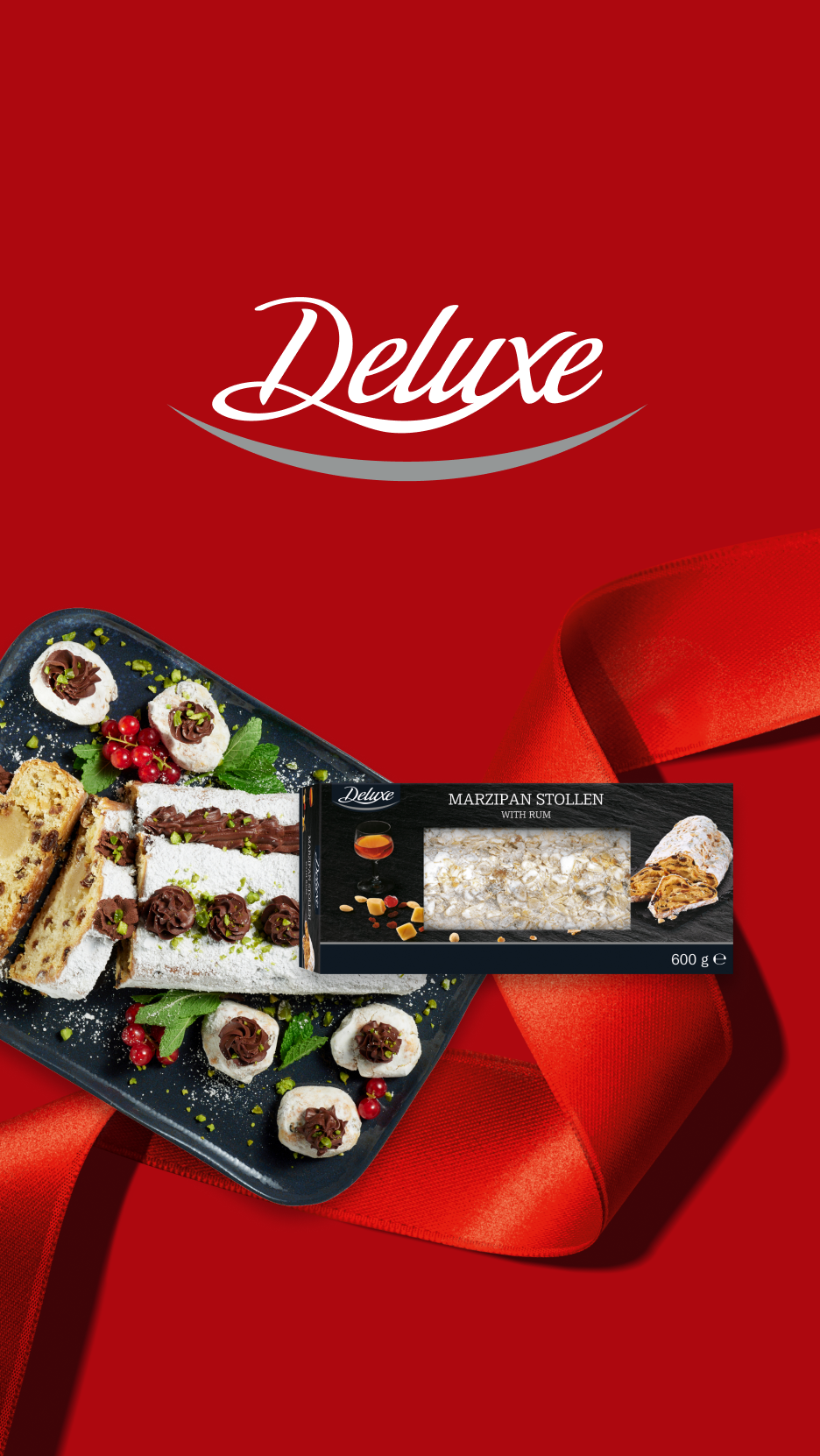 Deluxe Marzipan Stollen com rum, servido com doces e frutas vermelhas, sobre um fundo vermelho com fita.